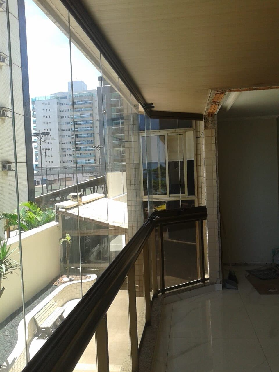 Varanda estreita fechada em vidro, integrada ao ambiente interno